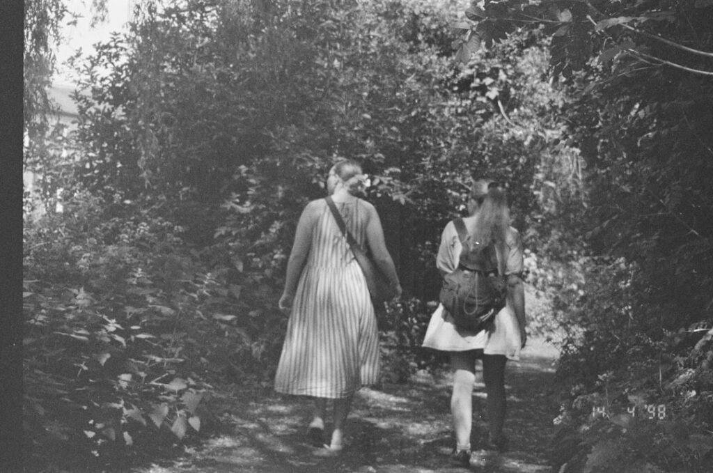 An old photo of two women walking in the woods
