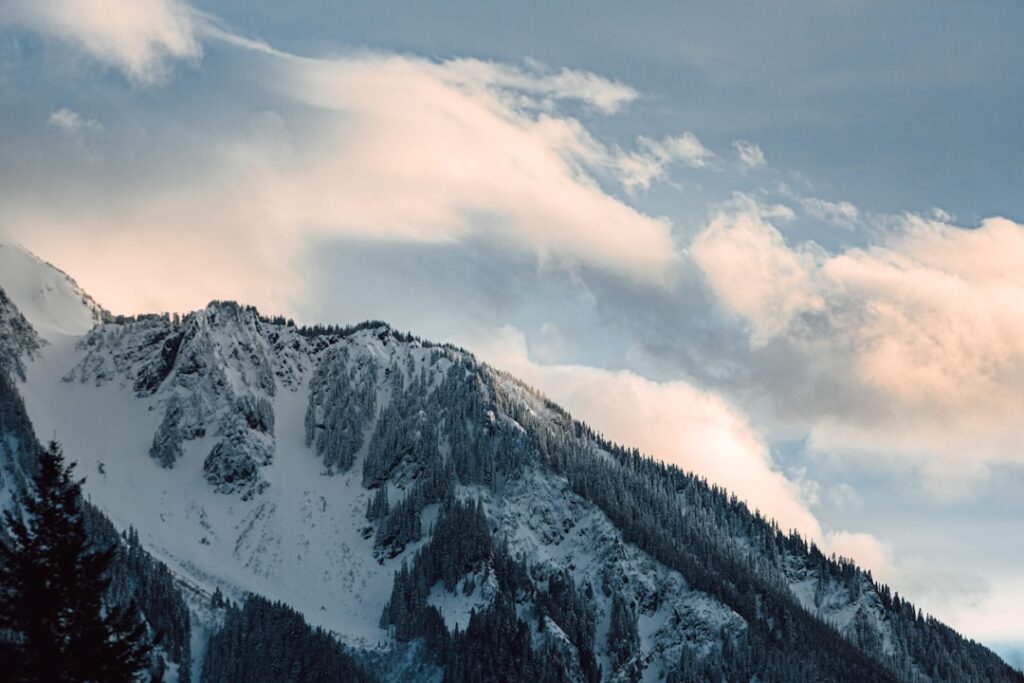 snow covered mountain under cloudy sky during daytime