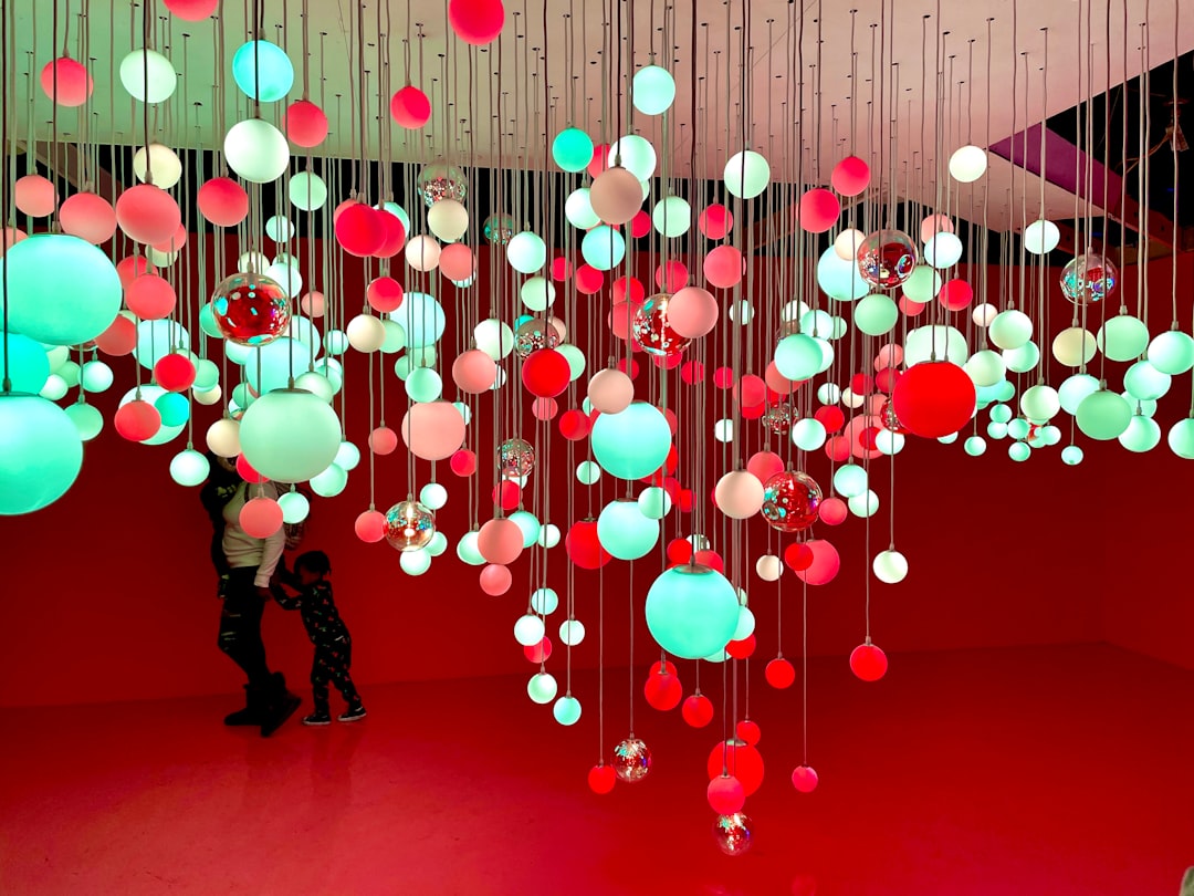 man in black jacket and pants holding red and white balloons