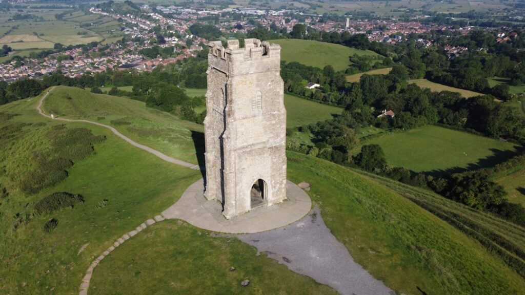 A tall tower sitting on top of a lush green hillside