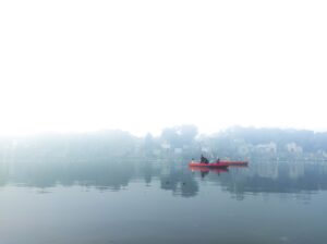a person in a red boat on a lake