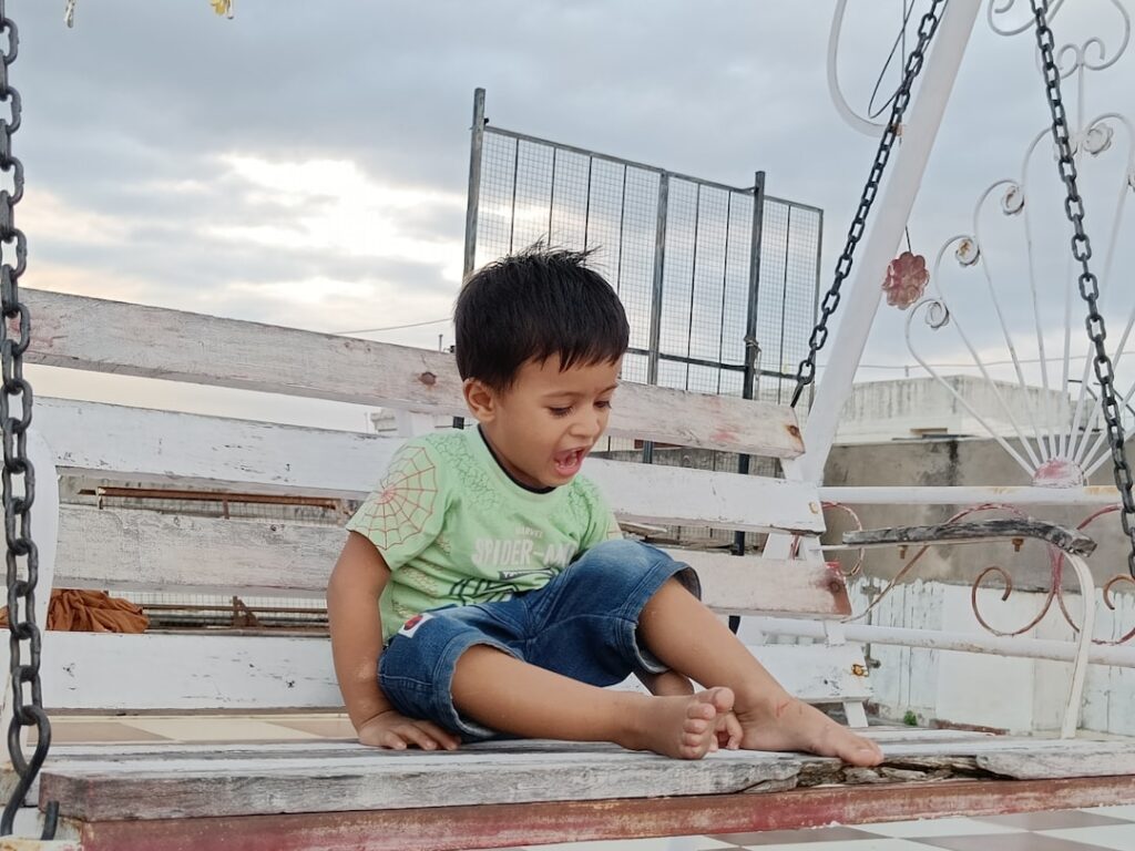 a young boy sitting on a porch swing